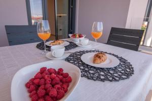una tavola con piatti di cibo e bicchieri di vino di Luxury apartment Porto with sea view and swimming pool a Premantura