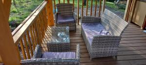 a porch with chairs and a couch on a deck at Yourte indépendante en pleine nature, proche d'Ajaccio in Carbuccia