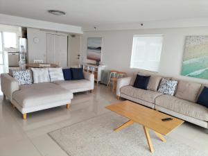 Sala de estar con 2 sofás y mesa de centro en Marriner Views, en Gold Coast