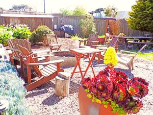 um quintal com cadeiras, uma mesa e flores em Shoreline Cottages em Fort Bragg