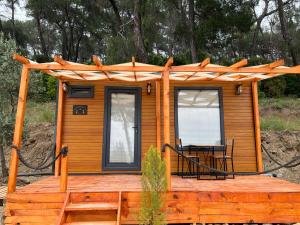 a small cabin with a table on a deck at Tiny Mini House in Dalaman