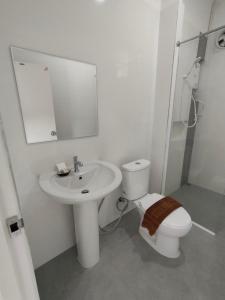 ein weißes Bad mit einem WC und einem Waschbecken in der Unterkunft King Fa House in Mae Sot