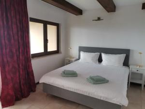 a bedroom with a white bed with two towels on it at Black Sea Rama Golf and Villas, Bell Tower Villa in Balchik