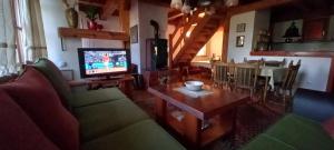 a living room with a couch and a tv and a table at Apartments Carevo Polje in Zlatibor