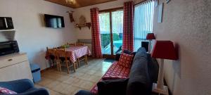a living room with a couch and a table at Hameau des chaumes vue panoramique in La Bresse
