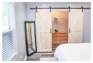 a bedroom with a sliding barn door next to a bed at Lovely 3BR 3BA Home minutes from Airport/Downtown Atlanta in Atlanta
