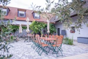 eine Terrasse mit einem Tisch, Stühlen und Sonnenschirmen in der Unterkunft Weingut Kernwein in Seinsheim