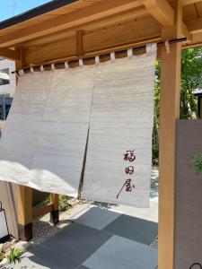a white curtain with asian writing on it at Hotel Fukudaya in Tokyo
