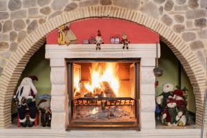 a brick fireplace with a fire in it at Hotel Fiordigigli in Assergi