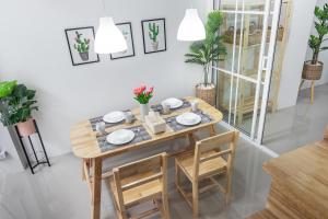 jadalnia z drewnianym stołem i krzesłami w obiekcie Ozzy's home@Banchang w mieście Ban Chang