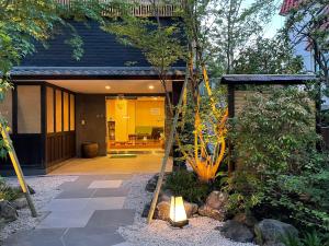 een huis met een tuin met een licht in de tuin bij Hotel Fukudaya in Tokyo