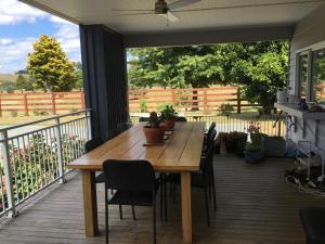a wooden table and chairs on a deck at Fairway views B & B in Matamata