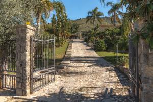 a gate at the end of a driveway at Villa Zagara Bagheria by Sicily in Villas in Portella di Mare