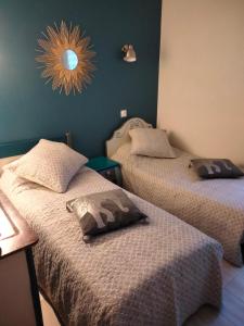 2 Betten in einem Zimmer mit einem Wandspiegel in der Unterkunft la dabinerie in Pruniers