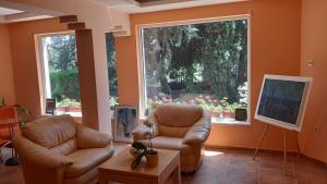 a living room with two leather chairs and a table at Motivi Hotel in Saints Constantine and Helena +46 photos