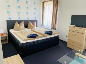 a bedroom with a bed with two blue towels on it at Waldhotel in Boizenburg