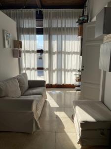 een woonkamer met een bank en een groot raam bij #soloperte B&B apartments in Molfetta +28 foto's