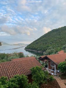 a view of a river with houses and a mountain at The Mussel House in Ksamil