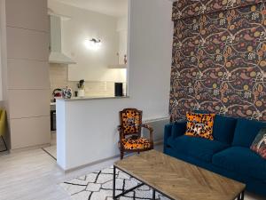 - un salon avec un canapé bleu et une table dans l'établissement Apartment- La Rochelle historic city centre, à La Rochelle