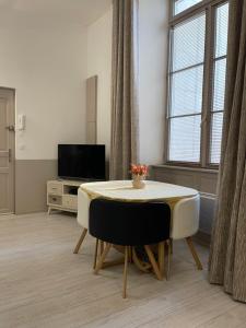 a living room with a table and a tv at Apartment- La Rochelle historic city centre in La Rochelle