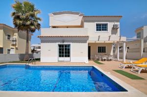a villa with a swimming pool in front of a house at Casa Ambar in Albufeira
