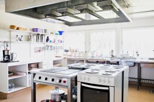 a kitchen with white counters and a stove top oven at Renfjällsgården in Edsåsdalen