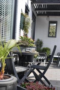 BenB de Walvis في Krimpen aan de Lek: طاولة وكراسي مع نباتات الفخار على الفناء