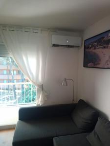 een woonkamer met een bank en een raam bij Apartamento con WiFi y Aire acondicionado en Pals Playa in Pals