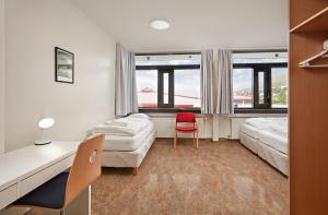 1 dormitorio con 2 camas, escritorio y silla en Hótel Torfnes, en Ísafjörður