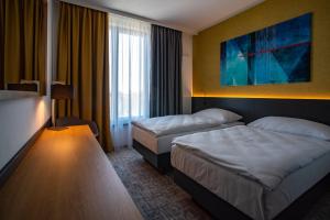 a hotel room with two beds and a window at EA Congress Hotel Aldis in Hradec Králové