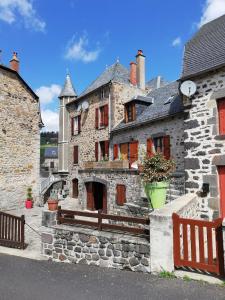 un vieux bâtiment en pierre avec un banc devant lui dans l'établissement Maison typique pleine de charme Peyrusse Cantal, à Peyrusse