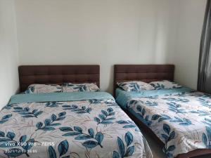 dwa łóżka siedzące obok siebie w sypialni w obiekcie ICOLOR HOME & STAY CH4 w mieście Tanah Rata