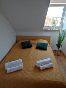 a bedroom with a bed with two pillows on it at Apartament u Beaty in Łeba