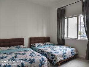 two beds sitting next to each other in a bedroom at ICOLOR HOME & STAY CH4 in Tanah Rata