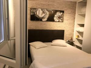 a bedroom with a white bed and flowers on the wall at Le clos de la cerise - Villa Gilbert in Châteauneuf-du-Pape