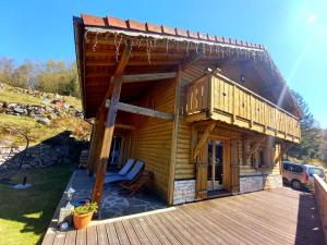 Cette grande maison en bois dispose d'une véranda et d'une terrasse. dans l'établissement Chalet Typique Vosgien "les Barbotines", à Ventron