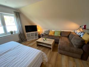 een woonkamer met een bank en een bed bij Ferienwohnung Ausguck in Jever