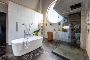 a bathroom with a white tub and a shower at Het Lichthuis in Zandvoort