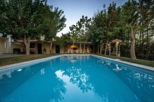 a large blue swimming pool in front of a house at VILLA ELENI in Anavyssos