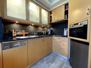 a kitchen with wooden cabinets and a stove top oven at KOZYGURU McMahons Point Amazing Water View Studio + FREE Parking NMP002 in Sydney