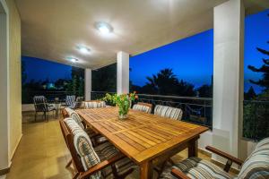 a patio with a wooden table and chairs at VILLA ELENI in Anavissos