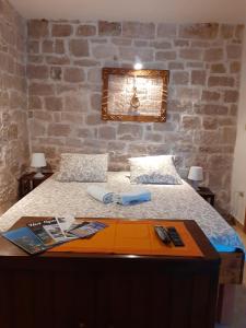 a bedroom with a bed with a stone wall at Apartments Agava & Lucija in Povlja