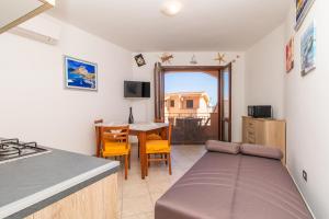 una cucina con un tavolo e un divano in una stanza di Toderix a Castelsardo