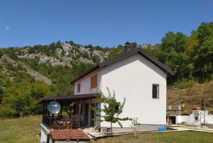 een klein wit huis met een dak bij Escape in nature in Stolac
