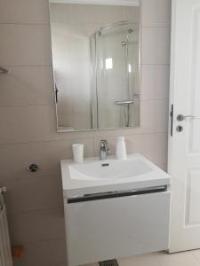 a white bathroom with a sink and a mirror at Casa Maia in Eforie Sud +40 photos