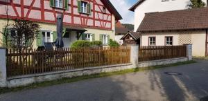 a wooden fence in front of two houses at Ferienhaus am Mühlbach in Kinding