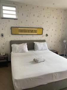 a white bed with a towel on top of it at Sole Hotel in Antananarivo