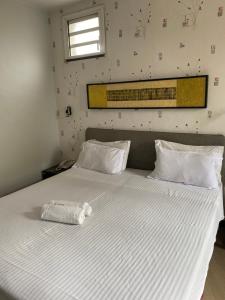 Sole Hotel في أنتاناناريفو: سرير ابيض وعليه كيس بلاستيك