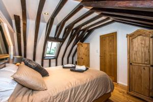 Schlafzimmer mit einem großen Bett mit Holzbalken in der Unterkunft Beautiful grade II listed 4 bed Victorian Conversion - Billericay Essex in Billericay
