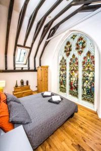 a bedroom with a bed and a stained glass window at Beautiful grade II listed 4 bed Victorian Conversion - Billericay Essex in Billericay